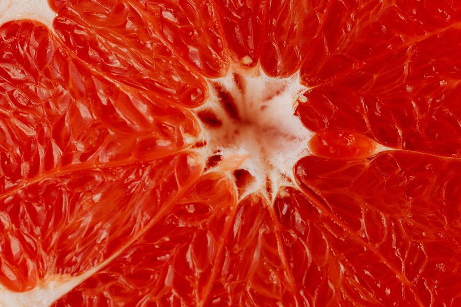 Vibrant close-up of a juicy red grapefruit slice showcasing its fresh, detailed texture.