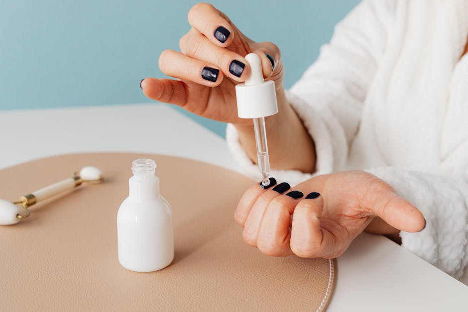 Close-up of a hand applying skincare serum with a dropper. Ideal for wellness and beauty themes.