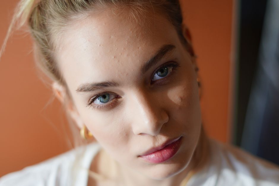 A close-up portrait capturing the thoughtful expression of a young woman with natural beauty.