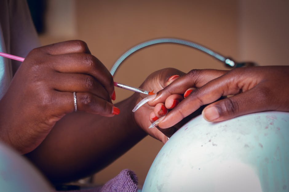 Detailed view of a nail technician applying polish during a manicure session.