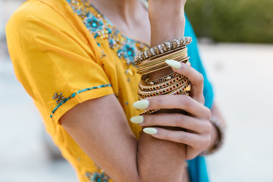 Close-up of a woman's arms adorned with traditional Indian bangles and vibrant attire.