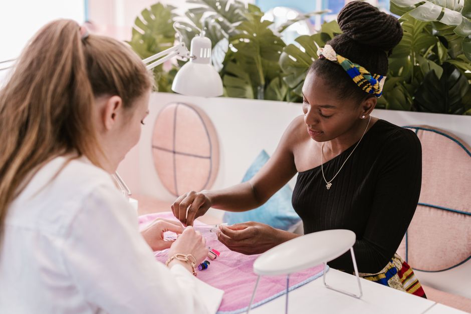 A professional manicurist provides nail care in a stylish, modern salon setting.