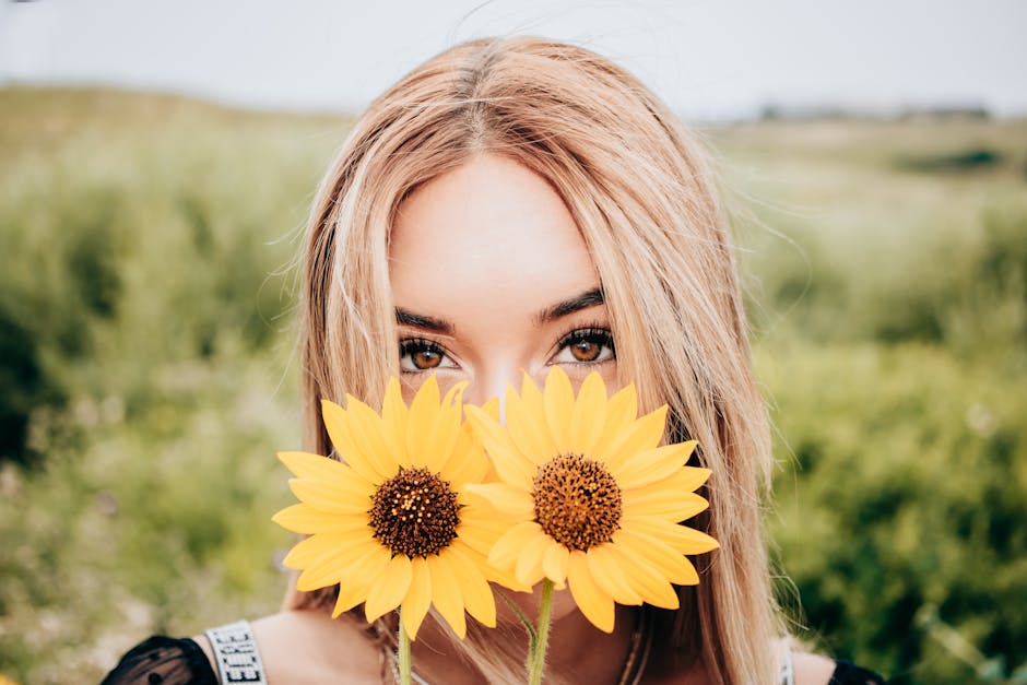 Caucasian woman holding sunflowers on a sunny day, showcasing natural beauty.