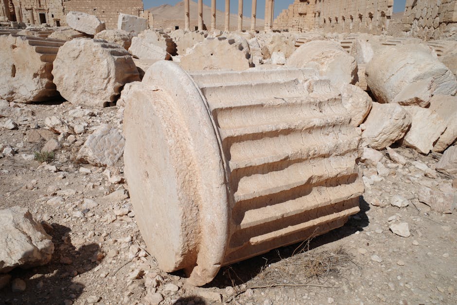 Fallen column fragments at historic Palmyra ruins, Syria, showcasing ancient architecture.