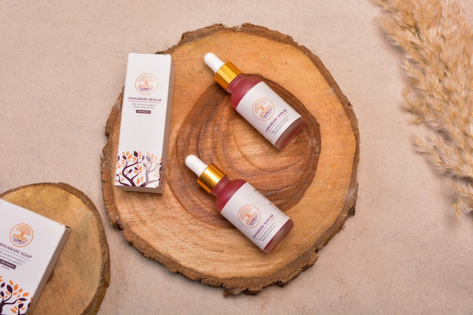 Elegant cosmetic serum bottles arranged on natural wood slices for a chic display.