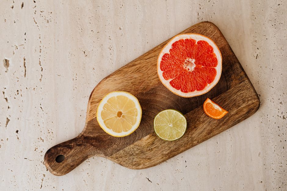 Top view of sliced citrus fruits on a rustic wooden board.