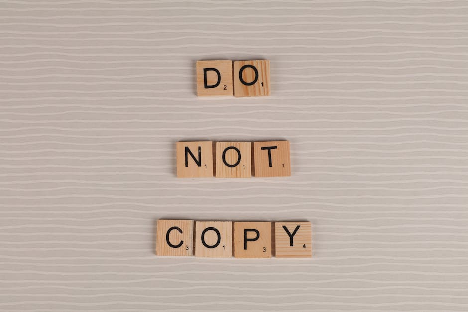 Close-up of wooden tiles spelling 'Do Not Copy' on a textured surface.